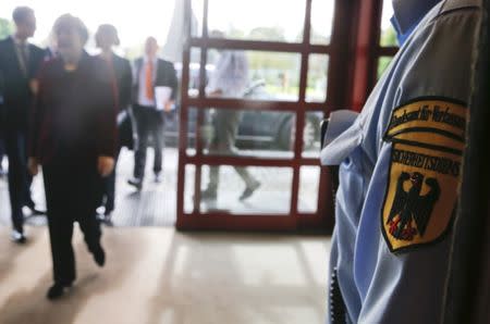 FILE PHOTO - A security officer of Germany's Bundesamt fuer Verfassungsschutz (BfV), the domestic intelligence service of the Federal Republic of Germany, stands guard as German Chancellor Angela Merkel arrives at the headquarters before her meeting with BfV president Hans-Georg Maassen in Cologne October 31, 2014. REUTERS/Wolfgang Rattay