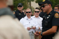 <p>Members of Richard Spencer’s security team, in white, stand behind police and decide who gets tickets to a speech by white nationalist Richard Spencer, who popularized the term ‘alt-right’, at the University of Florida campus on Oct.19, 2017 in Gainesville, Fla. (Photo: Brian Blanco/Getty Images) </p>
