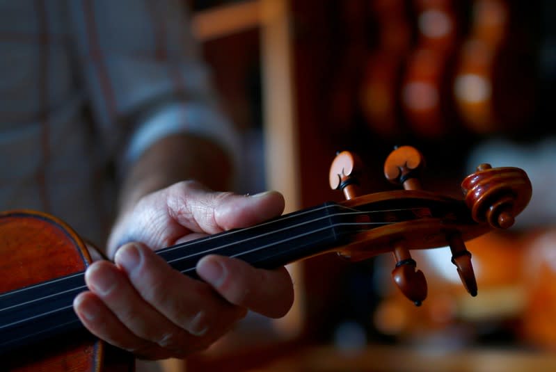 Svetozar Bogdanovski, an internationally recognised self-taught craftsman from Veles, holds a replica of an Antonio Stradivari's violin, at his shop in Veles