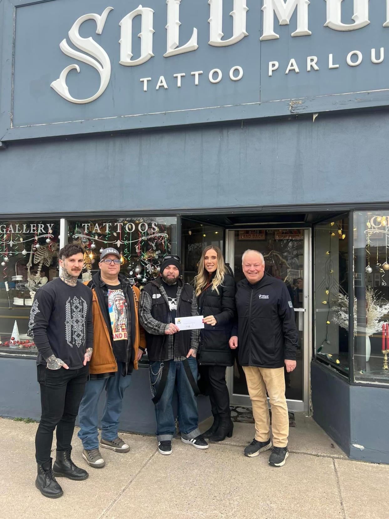 Chamber of Commerce Director Tony Haller and DDA Director Stephanie Sprecker announce Solomon's Tattoo Parlor as one of the winners of the second annual downtown business Christmas decoration contest.