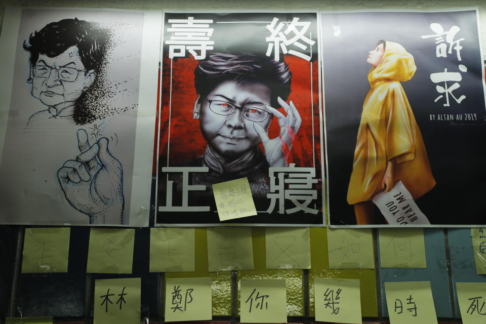 In this Friday, July 12, 2019, photo, post-it notes and a caricature of Hong Kong leader Carrie Lam are seen on their version Lennon Wall in Hong Kong. Hong Kong activists first created their own Lennon Wall during the 2014 protests, covering a wall with a vibrant Post-it notes calling for democratic reform. This time, they have taken to sticking the neon-colored notes everywhere, erecting impromptu Lennon Walls across the city as quickly as others might tear them down. Some protesters have called it "flowers blossoming everywhere." (AP Photo/Kin Cheung)