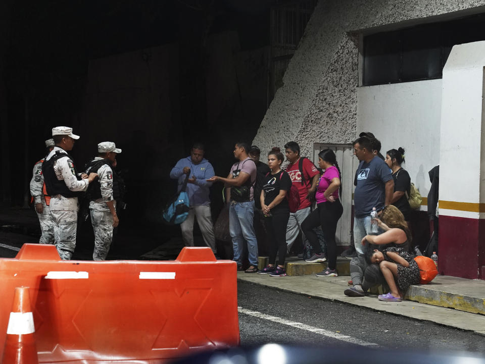 Venezuelan migrants are stopped by the National Guard at an army checkpoint on the road to Tonala, Chiapas state, Mexico, Wednesday, Oct. 5, 2022. The Biden administration has agreed to accept up to 24,000 Venezuelan migrants at U.S. airports, while Mexico has agreed to take back Venezuelans who come to the U.S. illegally over land. Effective immediately, those who walk or swim across the border will be immediately returned to Mexico under a pandemic rule known as Title 42 authority, which suspends rights to seek asylum under U.S. and international law on grounds of preventing the spread of COVID-19. (AP Photo/Marco Ugarte)