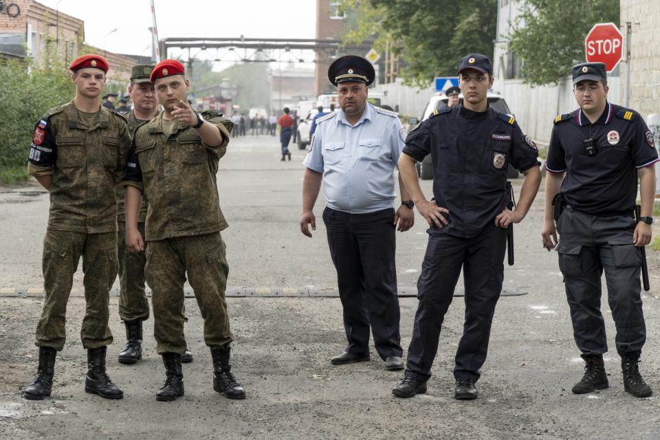 Military police and police officers guard an entrance of the side of the Zagorsk Optical and Mechanical Plant after the blast in the city of Sergiev Posad, Moscow Region, about 65 km (41miles) north-east of Moscow, Russia on Wednesday, Aug. 9, 2023. An explosion Wednesday, on the grounds of a factory north of Moscow that makes optical equipment for Russia's security forces wounded dozens people, six of them severely, officials said. (AP Photo)