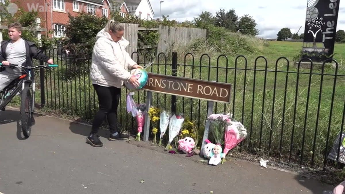 Flowers, balloons and teddy bears have been left at the site of the crash (PA)