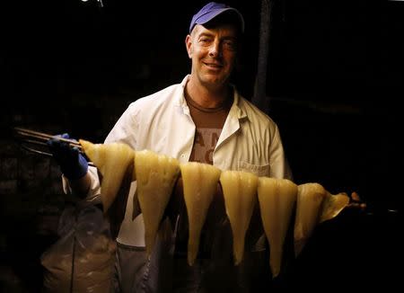 Fish processor Ian Button holds a rack of smoked haddock at his smokery in Grimsby, Britain, November 17, 2015. REUTERS/Phil Noble