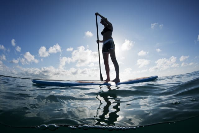 young female paddles a...