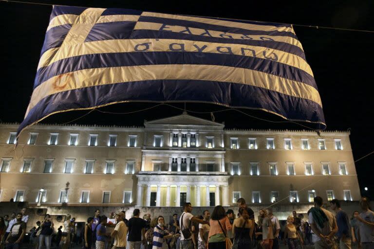 Una multitud esperó fuera del Parlamento de Grecia por la resolución sobre la adecuación al ajuste económico que se votaba: la llamada troika (FMI, el Eurogrupo y el Banco Central Europeo) le impuso un durísimo ajuste estructural a cambio de varios créditos por unos 350.000 millones de dólares.