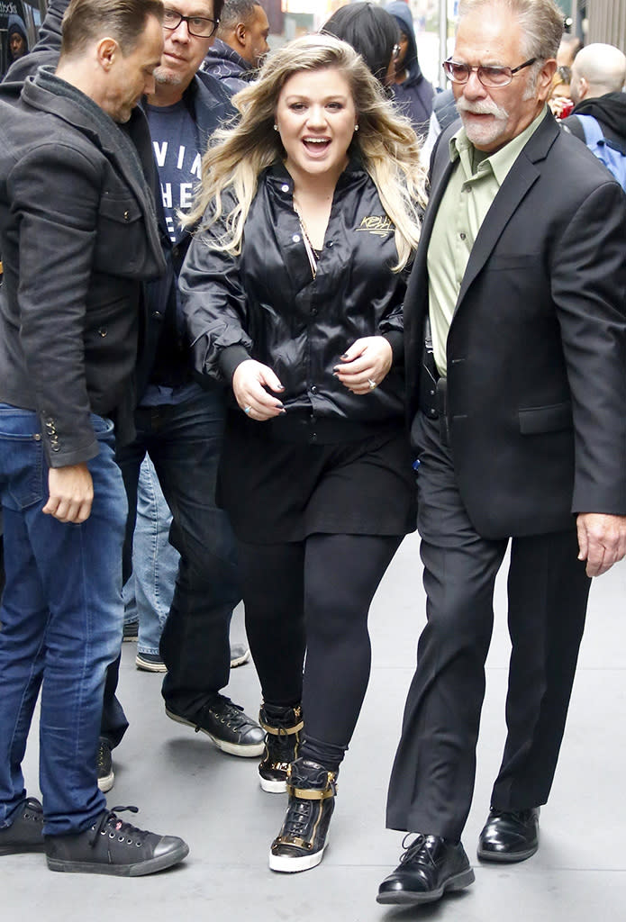 <p>The “Love So Soft” crooner was all smiles while outside the SiriusXM radio station in NYC. Clarkson looked very rock ‘n’ roll in an all black outfit topped off with a black satin jacket that had “Kelly” stitched on the front. (Photo: Best Image/BACKGRID) </p>