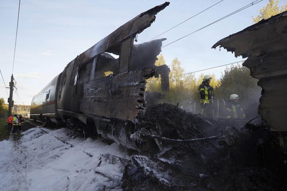 A firefighter works inside the remnants of a train after an ICE high-speed train caught fire in Dierdorf near Montabaur, western Germany, Friday, Oct. 12, 2018. Nobody was injured in the fire that broke out for unknown reasons. (Thomas Frey/dpa via AP)