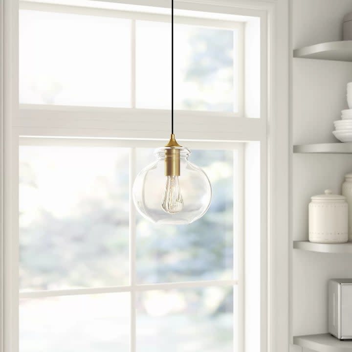 The fixture, featuring a light bulb with a transparent glass shade