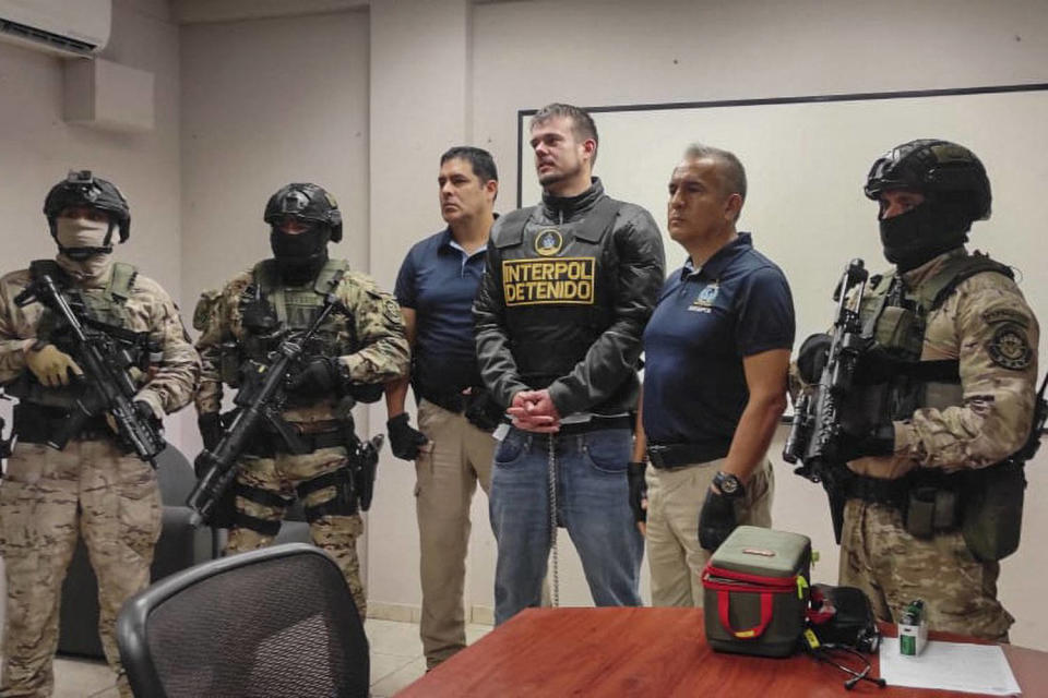 Peruvian police and Interpol agents handing over Joran Van der Sloot to FBI agents for a temporary extradition to the United States in Callao, Peru (Interpol Peru / AFP - Getty Images)