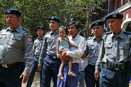 Detained Reuters journalist Kyaw Soe Oo is escorted by police as he holds his daughter while arriving for a court hearing after lunch break in Yangon, Myanmar February 14, 2018. REUTERS/Stringer