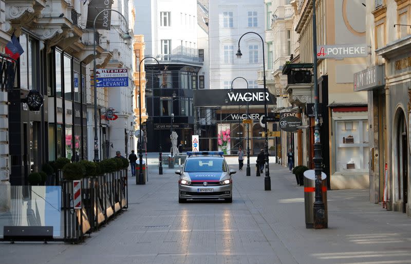 A police car passes closed shops in Vienna