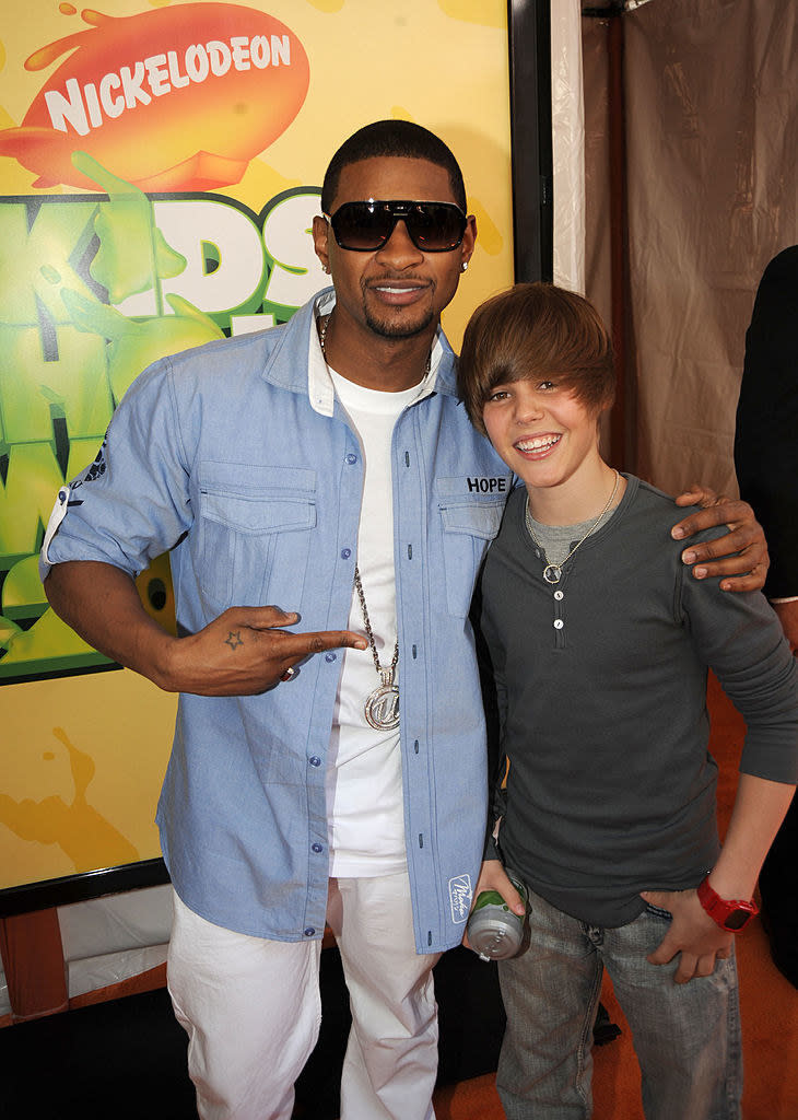 Usher is pointing at jb at the kid's choice awards