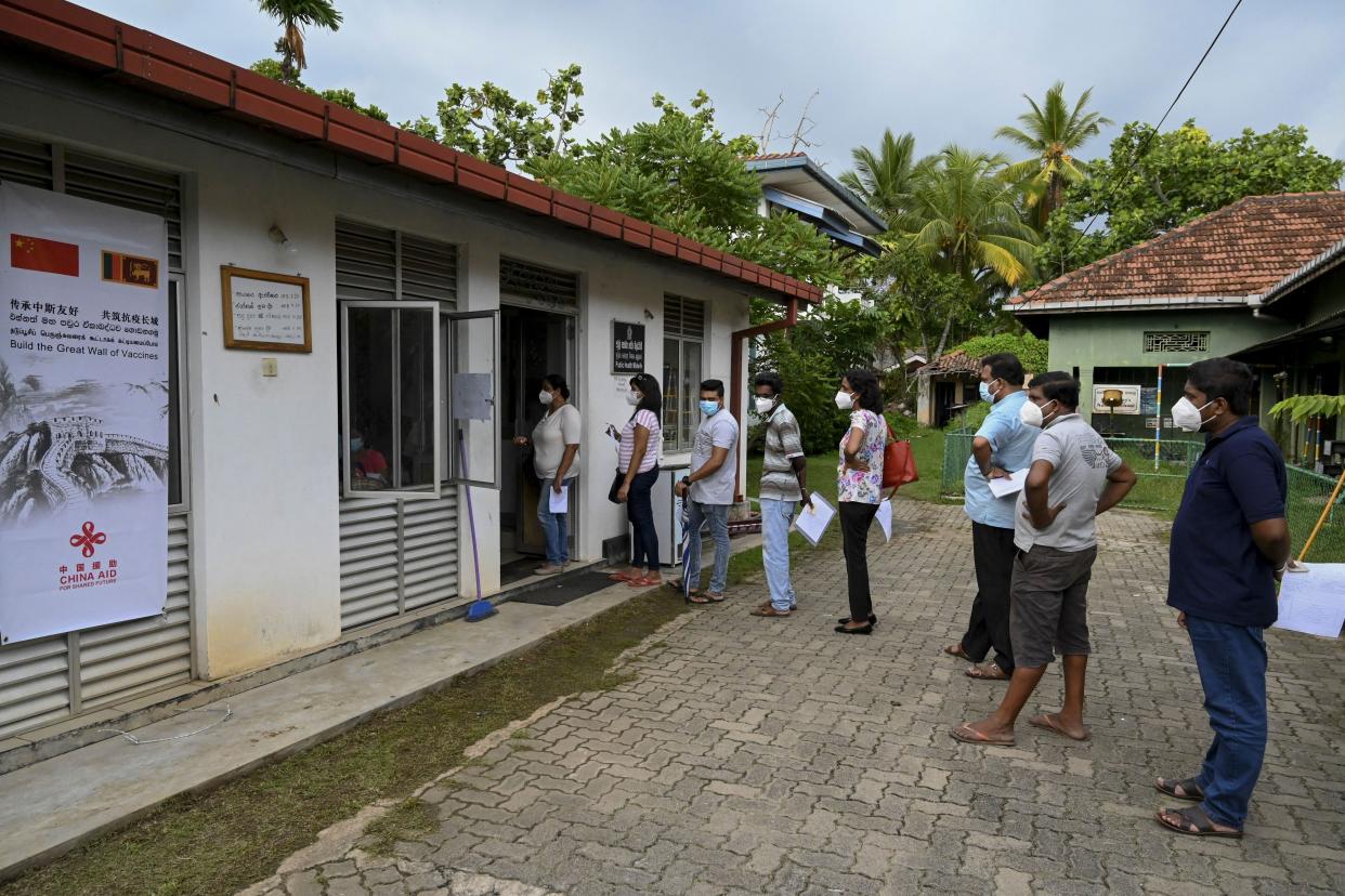People stand in a queue as they wait to get a dose of the Chinese-made Sinopharm COVID-19 vaccine in Panadura, a suburb of Sri Lanka's capital Colombo, on May 8, 2021.