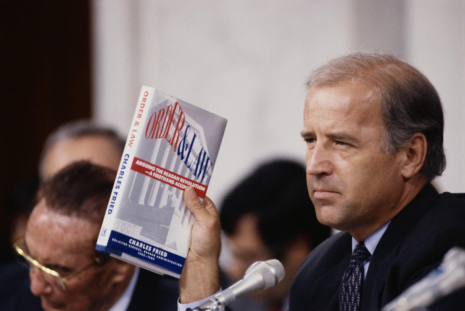 Joe Biden, then chairman of the Senate Judiciary Committee, holds up the book <i>Order and Law</i> by Charles Fried during the Clarence Thomas hearings. (Photo: Wally McNamee via Getty Images)