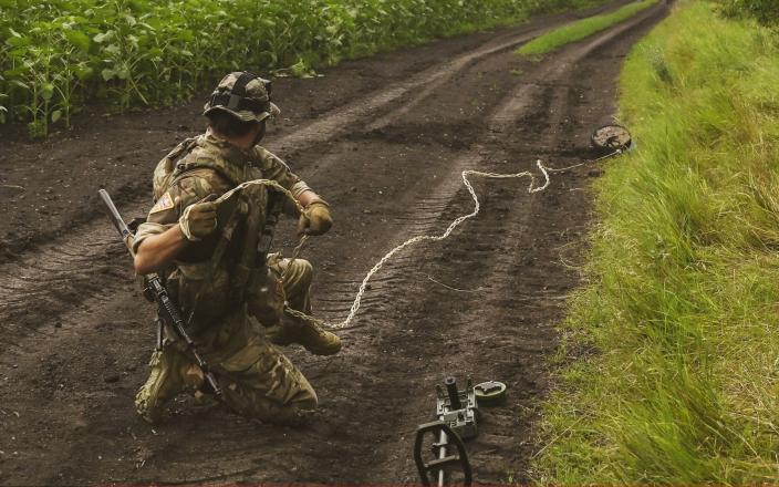 Ukrainian army's 35th Marine Brigade members conduct mine clearance work at a field in Donetsk, Ukraine