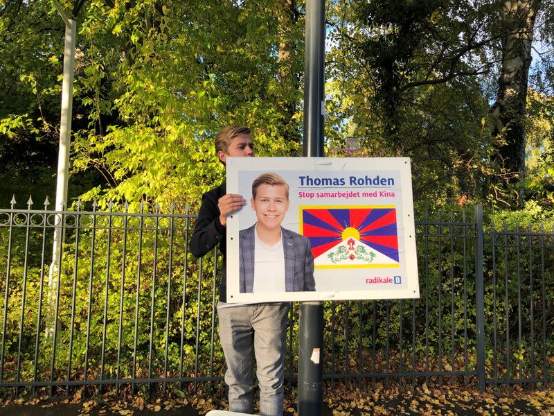 FILE PHOTO: Political candidate in upcoming local elections Thomas Rohden hangs up posters displaying him next to a Tibetan flag outside the Chinese embassy near Copenhagen