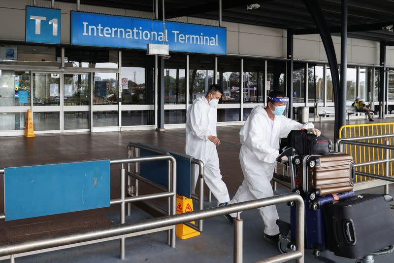 Travellers wear personal protective equipment outside the international terminal at Sydney Airport in Sydney