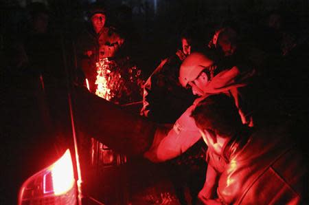 Afghan security forces load an injured man at the back of police car at the site of an explosion in Kabul, January 17, 2014. REUTERS/Omar Sobhani