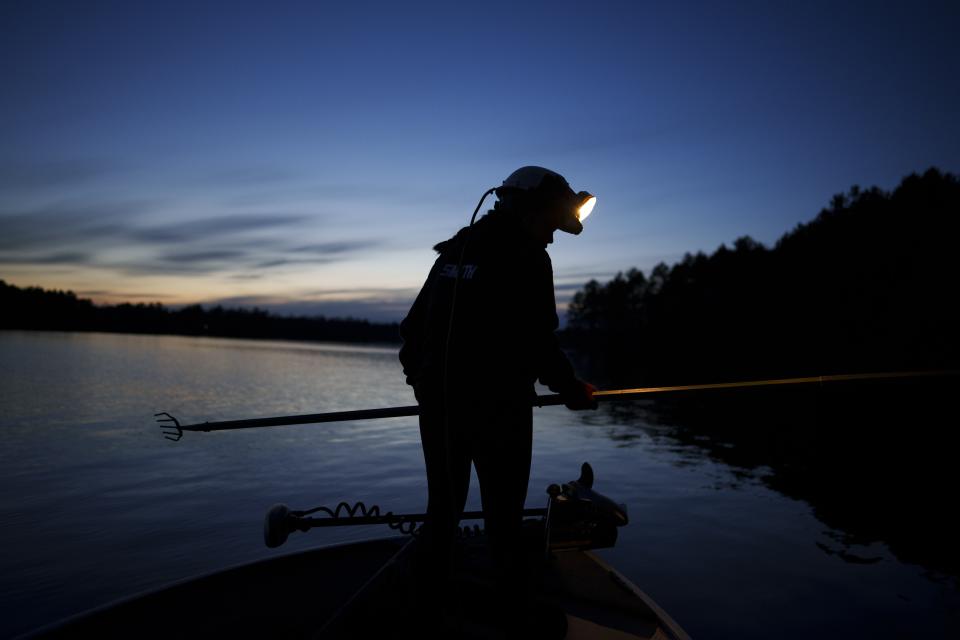 Kendall Smith holds a spear while fishing for walleye by headlight on Pokegama Lake during a youth spearfishing event Saturday, April 20, 2024, in Lac Du Flambeau, Wis. (AP Photo/John Locher)