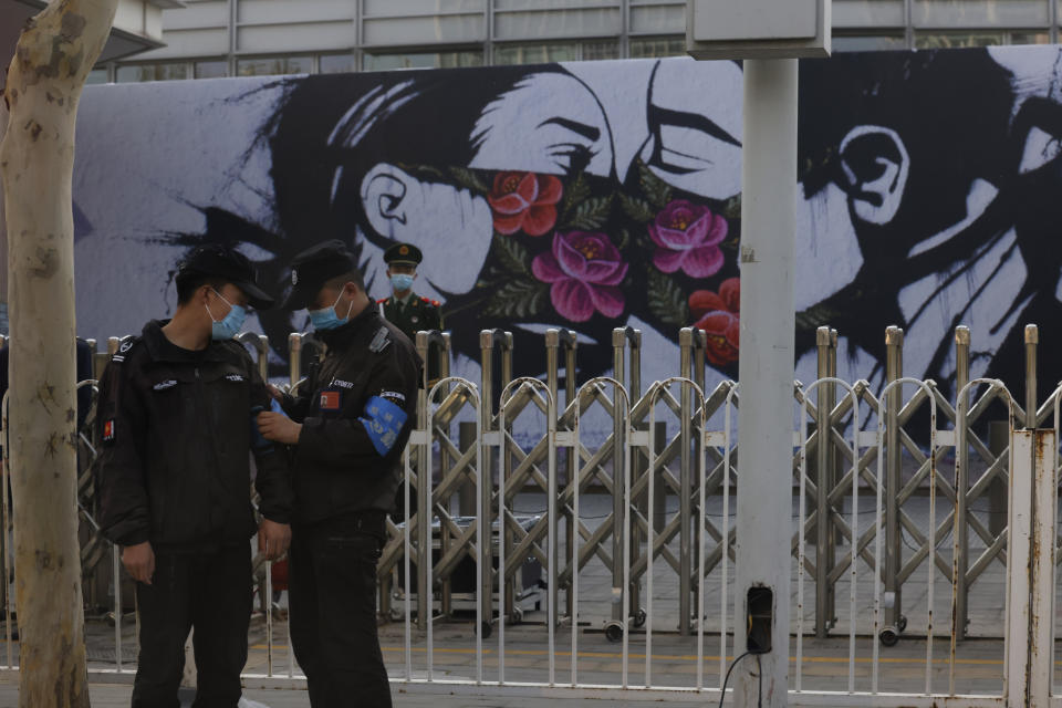 Chinese security personnel stand on duty near an art work outside the United States Embassy in Beijing on April 6, 2021. China accused the U.S. of causing humanitarian disasters through foreign military interventions in a report Friday, April 9, 2021 that was the latest broadside by Beijing amid increasingly contentious relations with the Biden administration. (AP Photo/Ng Han Guan)