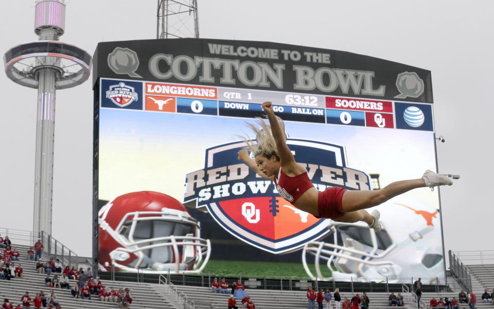 FILE - An Oklahoma cheerleader flies in the air before an NCAA college football game between Texas and Oklahoma at the Cotton Bowl, Saturday, Oct. 11, 2014, in Dallas. The Big 12 is losing its marquee matchup when the Red River Rivalry is played Saturday for the final time under the league’s umbrella. (AP Photo/LM Otero, File)
