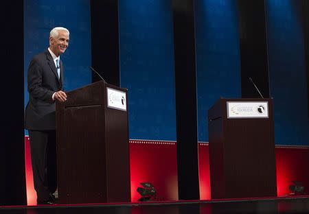 Former Florida Governor and challenger, Charlie Crist, appears alone for the first few minutes of a scheduled one hour debate, as Florida Governor Rick Scott delays taking the stage, during their gubernatorial debate in Davie, October 15, 2014. REUTERS/Andrew Innerarity