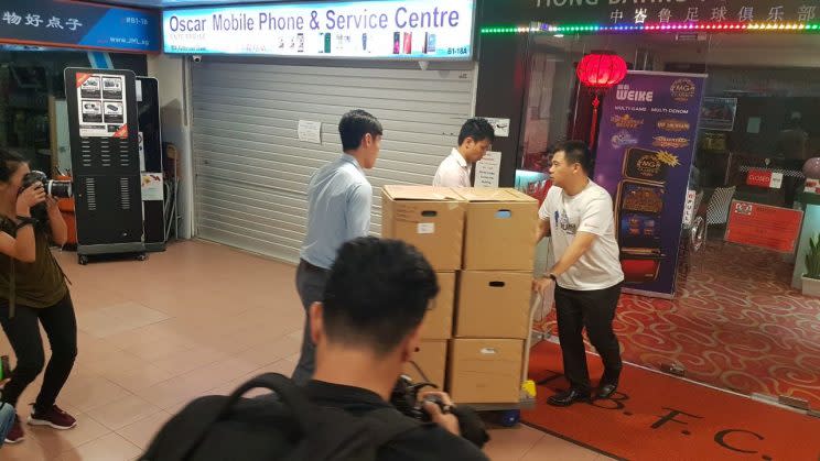 Boxes being removed by police officers from the Tiong Bahru Football Club premises. Photo: Yahoo Singapore