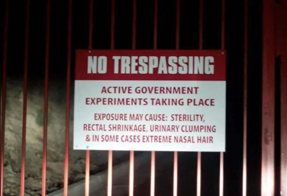 Sign warning against trespassing due to active government experiments with humorous exaggerated side effects