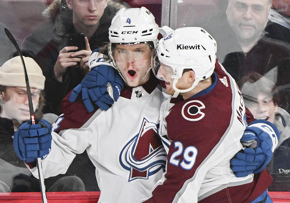 Colorado Avalanche's Bowen Byram celebrates with teammate Nathan MacKinnon after scoring against the Montreal Canadiens during the first period of an NHL hockey game in Montreal, Monday, March 13, 2023. (Graham Hughes/The Canadian Press via AP)