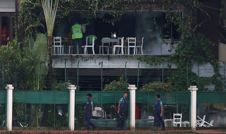 Policemen patrol outside the Holey Artisan Bakery and the O'Kitchen Restaurant as others inspect the site after gunmen attacked, in Dhaka, Bangladesh, July 3, 2016. REUTERS/Adnan Abidi