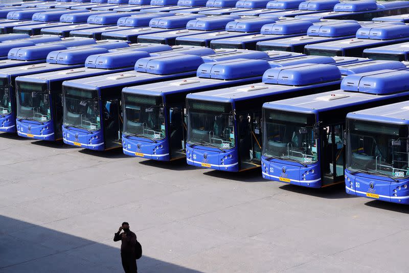 A man stands as buses are seen parked at a depot during lockdown by the authorities to limit the spreading of coronavirus disease (COVID-19), in New Delhi