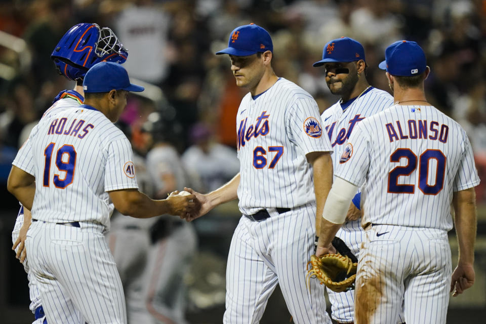 New York Mets relief pitcher Seth Lugo hands the ball to manager Luis Rojas during the eighth inning of the team's baseball game against the San Francisco Giants on Thursday, Aug. 26, 2021, in New York. (AP Photo/Frank Franklin II)