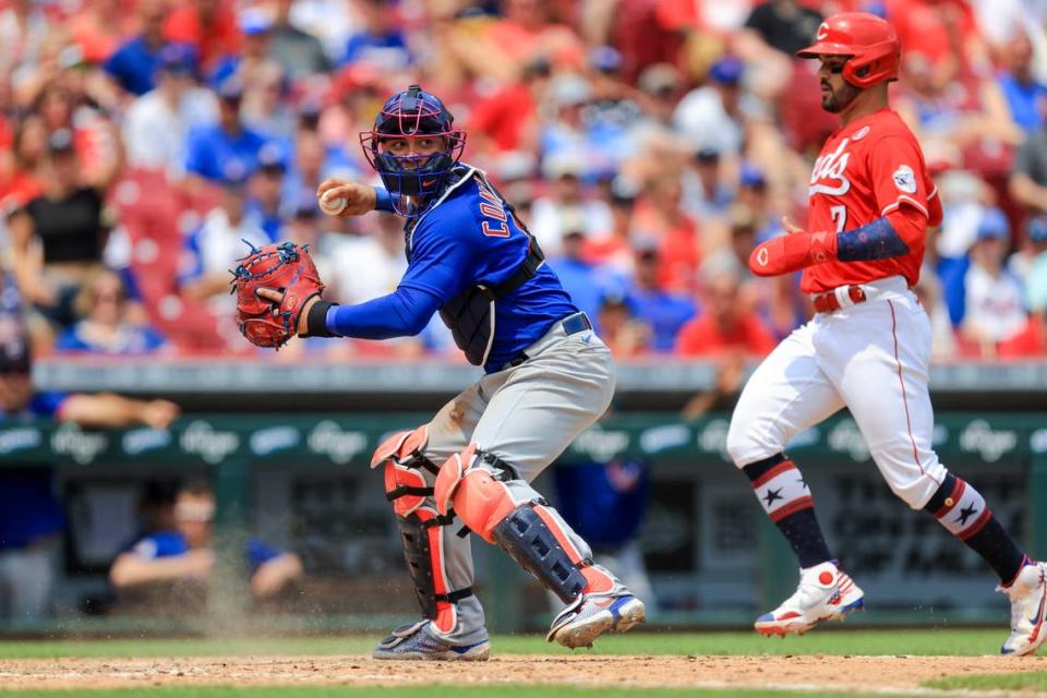 Chicago Cubs catcher Willson Contreras, left, looks to throw to first base as he forces out Eugenio Suarez of the Cincinnati Reds at home plate during a game in 2021. Contreras is one of the options the St. Louis Cardinals could pursue this offseason to replace longtime catcher Yadier Molina, who retired.