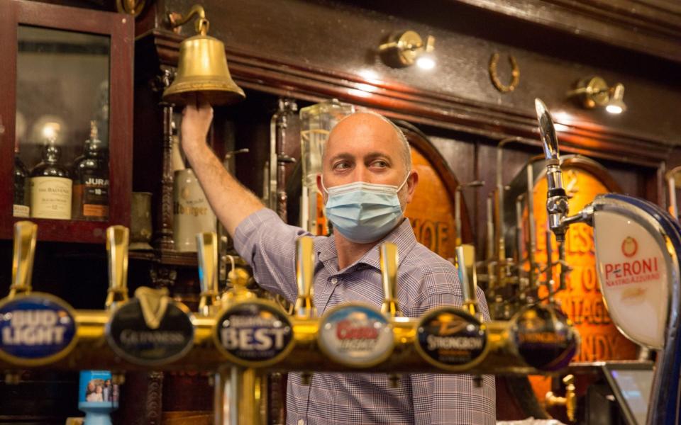 General manager Michael Rogerson rings for last orders in the Horseshoe Bar in Glasgow - Robert Perry/Shutterstock