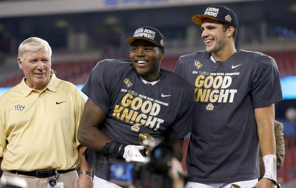 Central Florida head coach George O'Leary, left, watches as players Terrance Plummer, middle, and Blake Bortles, right, smile at the crowd and teammates after a Fiesta Bowl NCAA college football game win against Baylor Wednesday, Jan. 1, 2014, in Glendale, Ariz. Central Florida defeated Baylor 52-42. (AP Photo/Ross D. Franklin)