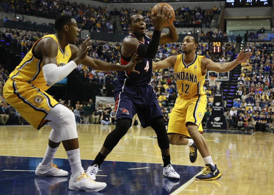 Atlanta Hawks forward Paul Milsap (4) keeps the basketball from Indiana Pacers center Ian Mahinmi, left, and Pacers forward Evan Turner in the first half of an NBA basketball game in Indianapolis, Sunday, April 6, 2014. (AP Photo/R Brent Smith)