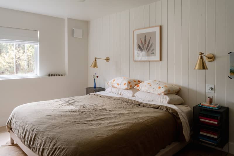 Neatly made bed in light filled bedroom.