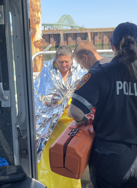 Dan Ho, 63, at left, being treated by medics after having been rescued after treading water for five hours in the Atlantic Ocean off the coast of Long Island, Monday, July 31, 2023, in Babylon, N.Y. Suffolk County Police say Ho went swimming at a beach and was pulled out to open water by the current.