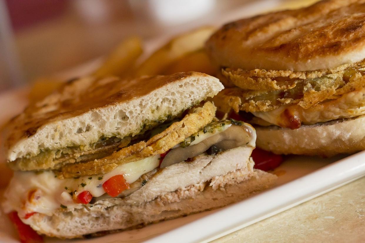 Grilled chicken and portobello mushroom panini with crispy onion rings and a side of golden fries