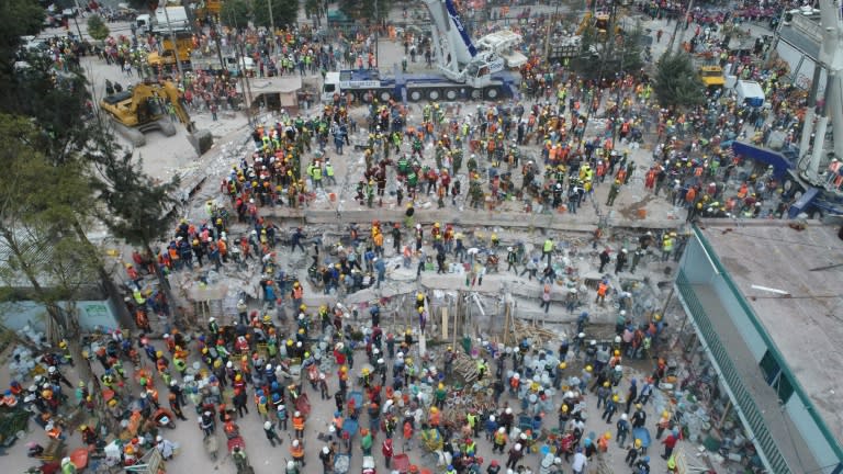 This aerial view shows firefighters, policemen, soldiers and volunteers searching for survivors in a flattened building in Mexico City