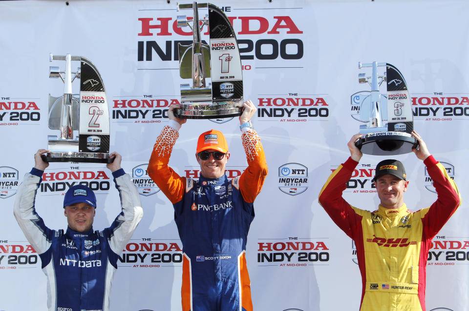 Scott Dixon, center, celebrates winning the IndyCar Series auto race at Mid-Ohio Sports Car Course with second place finisher teammate Felix Rosenqvist, left, and third place finisher Ryan Hunter-Reay, Sunday, July 28, 2019 in Lexington, Ohio. (AP Photo/Tom E. Puskar)