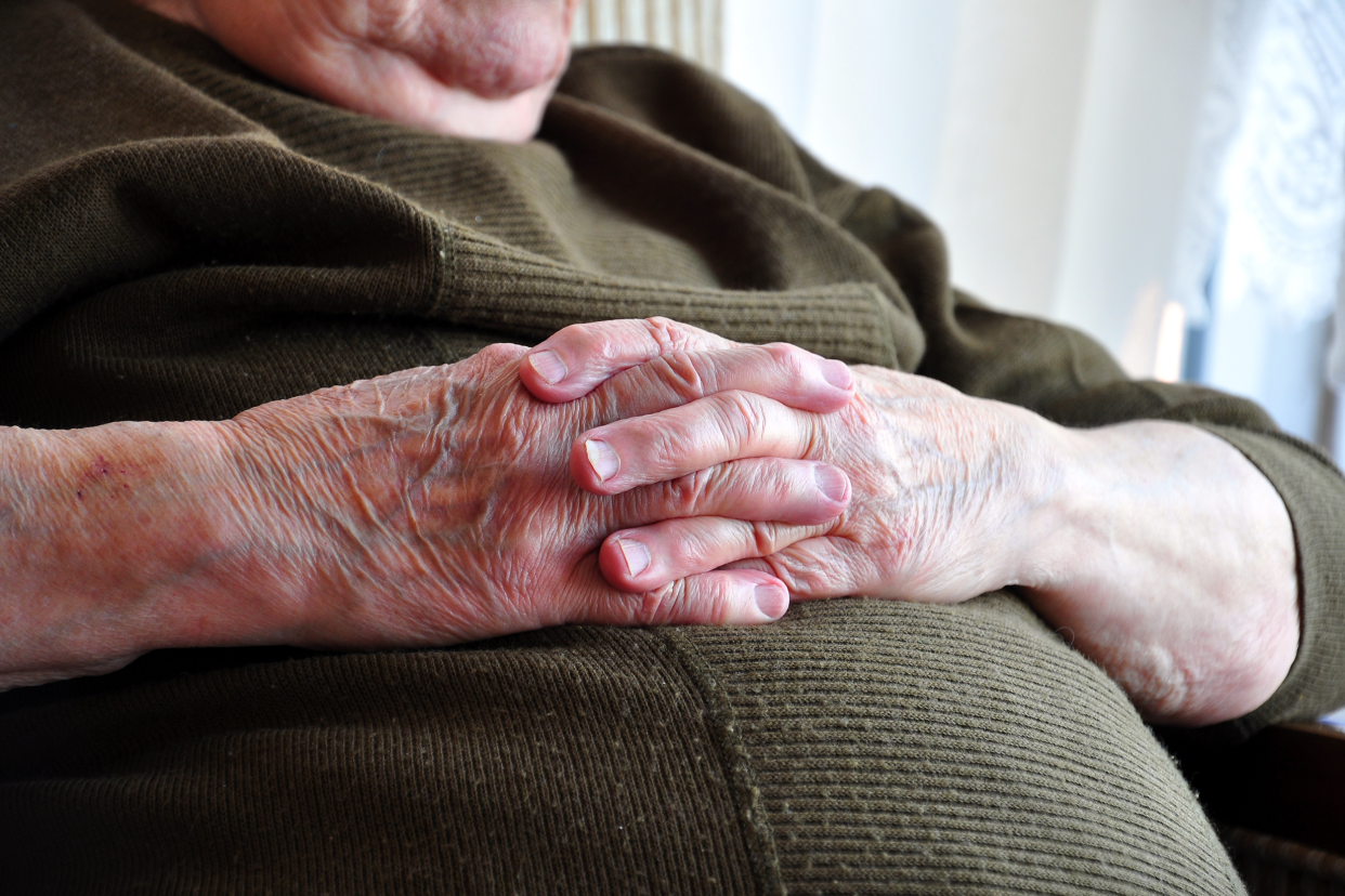 Obese senior sitting with his hands on his belly