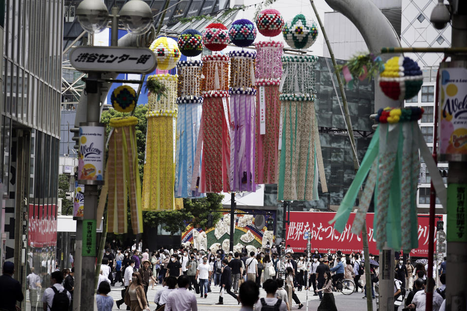 People wearing masks against the spread of the new coronavirus walk at Shibuya pedestrian crossing in Tokyo Friday, July 31, 2020. The Japanese capital confirmed Friday more than 400 new coronavirus cases. (AP Photo/Eugene Hoshiko)