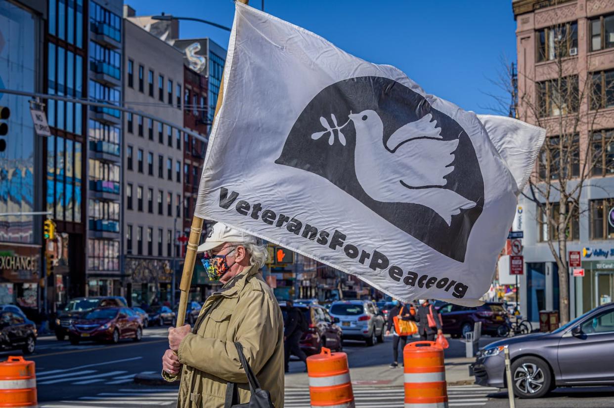 A participant at an anti-war protest marches in New York City in March 2021. <a href="https://media.gettyimages.com/id/1231820484/photo/participant-seen-holding-a-flag-at-the-protest-anti-war.jpg?s=612x612&w=gi&k=20&c=X2fZ2fahtnH3Nf-8bMygS5w348yqTgo81dW5o3Jr2GI=" rel="nofollow noopener" target="_blank" data-ylk="slk:Erik McGregor/LightRocket via Getty Images;elm:context_link;itc:0;sec:content-canvas" class="link ">Erik McGregor/LightRocket via Getty Images </a>
