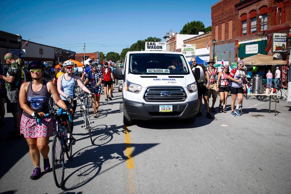 A SAG wagon parts the sea of cyclists as they enter Anita during RAGBRAI in 2019.