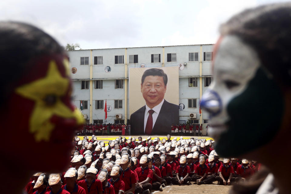Indian school children wear face masks of Chinese President Xi Jinping to welcome him on the eve of his visit in Chennai, India, Thursday, Oct. 10, 2019. Chinese President Xi Jinping is coming to India to meet with Prime Minister Narendra Modi on Friday, just weeks after China supported Pakistan in raising the issue of India's recent actions in disputed Kashmir at the U.N. General Assembly meeting in New York. (AP Photo/R. Parthibhan)
