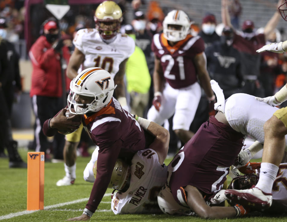 Virginia Tech quarterback Hendon Hooker, left, scores in the first half of an NCAA college football game against Boston College in Blacksburg Va. Saturday, Oct. 17, 2020. (Matt Gentry/The Roanoke Times via AP, Pool)