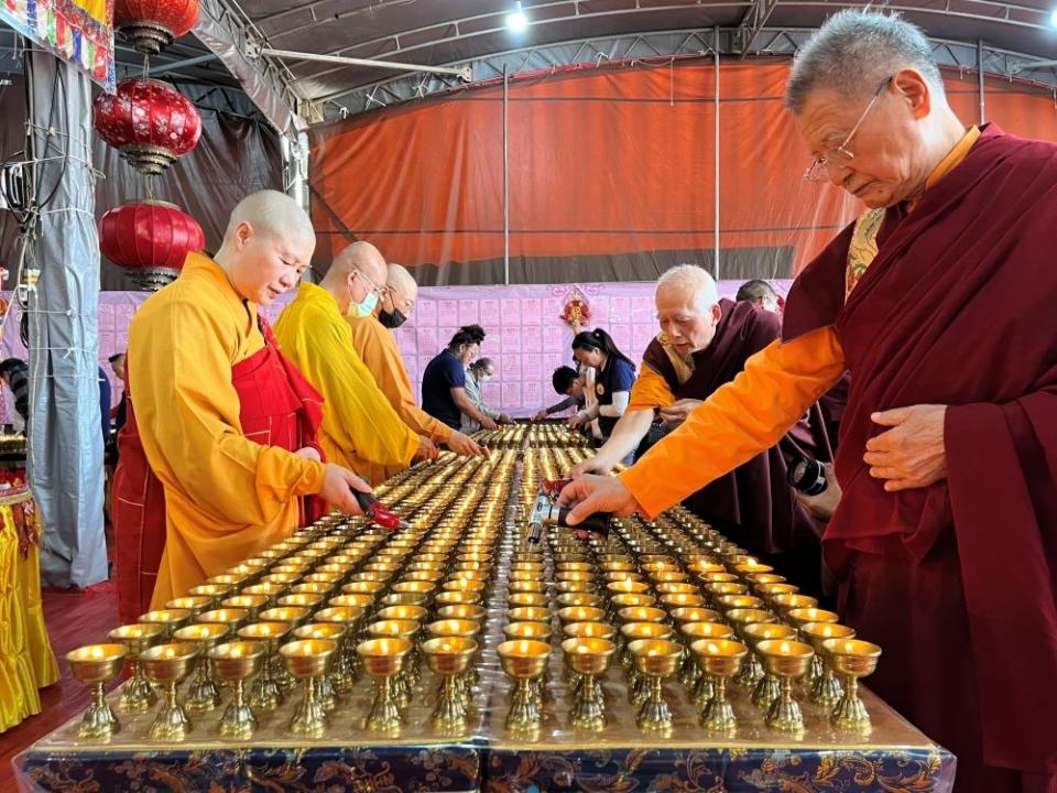 《圖說》2024年農曆初三、初四萬燈供佛法會供燈六萬九千餘盞，世界佛教總部副主席聖德釋證達教尊(左一)率信眾點燃萬燈供佛。